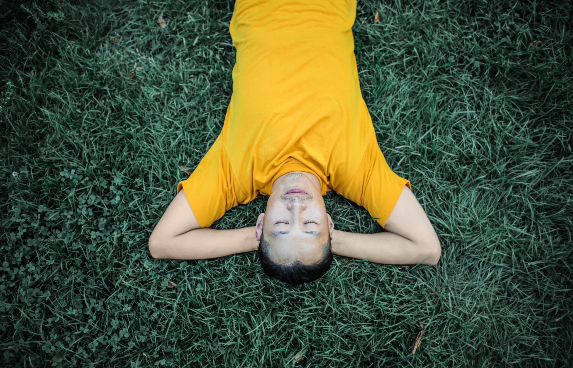 photo of person laying on grass field
